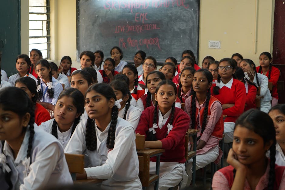Group of schoolgirls in uniform attentively listening in a classroom setting