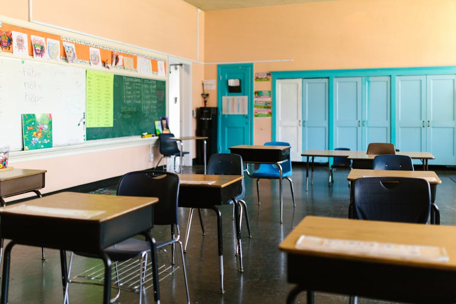 Bright and colorful empty classroom with desks, blackboard, and educational materials.